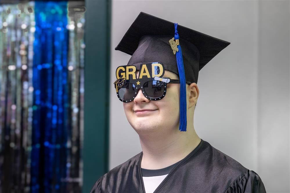 A student smiles while wearing sunglasses.